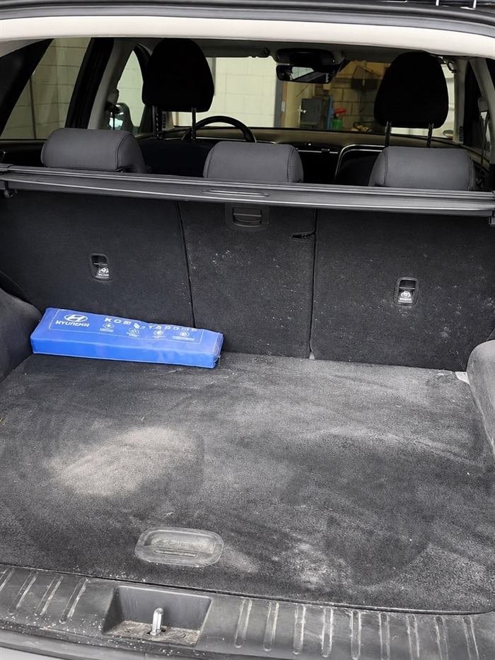 Voor interieurreiniging: kofferbak met ingelopen stof en zand in de bekleding