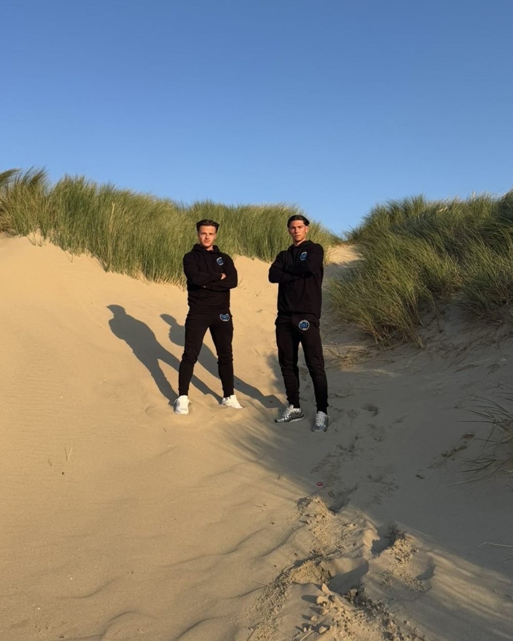 Zeno en Renzo, oprichters van Detailing by DBZ, in DBZ-werkkledij aan de kust